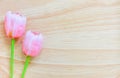 Pink artificial tulips on wood background, copy space