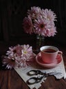 Pink aster, pink cup of tea and scissor stilllife