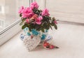 Pink azalea in a vintage pot on a window