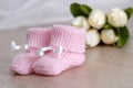 Pink baby booties on wooden surface Royalty Free Stock Photo