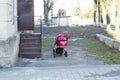 Pink baby carriage stand outdoors near stairs to the house in sunny day without parents. Irresponsibility young mother