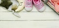 Pink baby girl shoes, newborn clothes and soft toys. Motherhood, education or pregnancy concept with copy space. Baner Royalty Free Stock Photo