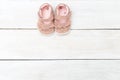 Pink baby girl shoes on white wooden background. Copy space Royalty Free Stock Photo