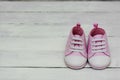 Pink baby girl sneakers, sport shoes close up on gray background. Newbord, motherhood, pregnancy concept with copy space