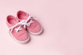 Pink baby shoes on pink background, concept of first steps, birthday, expectation, pregnancy, maternity, motherhood, parenthood. Royalty Free Stock Photo