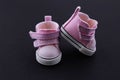 Pink baby shoes on a black background. The concept of first steps, birthday, expectation, pregnancy, motherhood, motherhood, Royalty Free Stock Photo