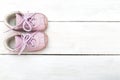 Pink baby shoes for girls on a white wooden background Royalty Free Stock Photo