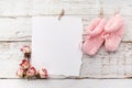 Pink baby's booties. Small girls sock and blank card on white wooden background Royalty Free Stock Photo