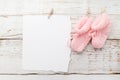 Pink baby's booties. Small girls sock and blank card on white wooden background Royalty Free Stock Photo