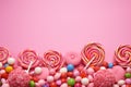 Pink background adorned with sweet lollipop and candy, tempting treats