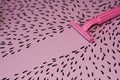 Pink background with marker drawn hairs and female razor for depilation.