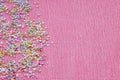 Pink background with multicolored confetti for manicure design on copy space. Royalty Free Stock Photo