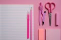 On a pink background, school accessories and a pen, colored pencils, a pair of compasses, a pair of compasses, Copy space, top vie
