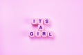 pink background with text from the cubes - it's a girl, the concept of a newborn girl