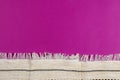 Pink background with white embroidered fabric with fringe