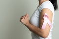 Pink badge ribbon on praying woman arm to support breast cancer cause. breast cancer awareness concept Royalty Free Stock Photo