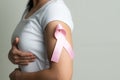 Pink badge ribbon on woman arm to support breast cancer cause. breast cancer awareness concept Royalty Free Stock Photo