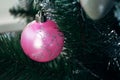 Pink ball on artificial Christmas tree. Selective focus. Holiday card with decorations for the New Year`s Eve Royalty Free Stock Photo