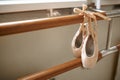 Pink ballet shoe hanging on barre, nobody