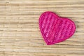 Pink bamboo wood heart on reed texture background, love and romance symbol Royalty Free Stock Photo