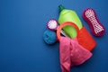 Pink basket with washing sponges, brushes and cleaning agent in a green plastic bottle on a blue background Royalty Free Stock Photo