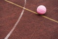 Pink basketball ball on the ground. Close-up ball on the red court.