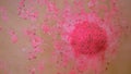 Pink bath bomb dissolves in water Royalty Free Stock Photo