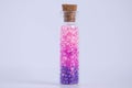 Pink beads are poured into a glass bottle. Magic pills. Close-up Royalty Free Stock Photo