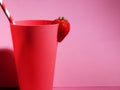 Pink beaker with strawberry and drinking straw Royalty Free Stock Photo