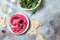 Pnk beet hummus spread or dip with mix salad leaves. Healthy raw summer appetizer, vegan, vegetarian snack.