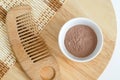 Pink bentonite clay powder in the bowl and hair brush. Clay texture close up. Diy facial or hair mask, dry shampoo and body wrap