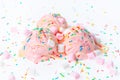 berry scoops ice cream covered and strewed sprinkles, marshmallows and icing on white background Royalty Free Stock Photo