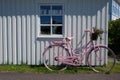 Pink bicycle in front of white house in Sweden