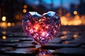 A pink big cut diamond heart with red lights inside if it standing on wet pavement. Blurred fire and bokeh lights on a