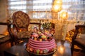 Pink birthday cake decorated with fruits, candies and macarons for a little girl