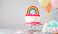 Pink Birthday Cake with Rainbow decoration and balloons at a Party Royalty Free Stock Photo