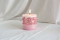 Pink number 127 birthday candle on white background Royalty Free Stock Photo