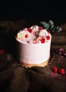 Pink birthday cream cake with fruits and chocolate on the top on dark background. Vertical photo of beautiful cake - tart