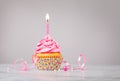 Pink Birthday Cupcake with Candle over Grey Background Royalty Free Stock Photo