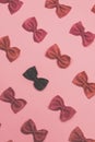 Pink and black pasta farfalle lies diagonally