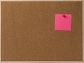Pink Blank sticky notes red pinned into brown corkboard.
