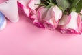 Pink blooming roses and face cream on pastel pink background. Romantic skincare floral frame. Copy space Royalty Free Stock Photo