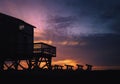 Silhouette sunset seascape with beach house with deck and ruined pilings