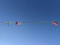 Pink and blue clothes pegs hanging on a yellow washing line in the sky Royalty Free Stock Photo