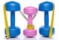 Pink and blue dumbells with a tape measure Royalty Free Stock Photo