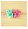 Pink and blue jelly gummy bear on wooden background. Polaroid photo. Royalty Free Stock Photo