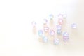 Pink and blue multicolored beautiful crystal drops beads over white wooden background Royalty Free Stock Photo