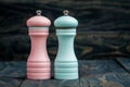 Pink and Blue Pepper Mills on Wooden Background