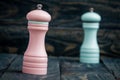 Pink and Blue Pepper Mills on Wooden Background