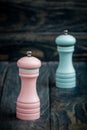 Pink and Blue Pepper Mills on Wooden Background